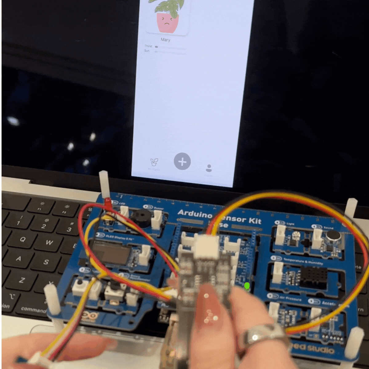 This is the external view of me testing it with my hands. I triggered the resistor on the light sensor to quickly give the illusion of more or less light for my test and I used my hands on the soil moisture sensor to do the same thing so I could test my prototype right away.